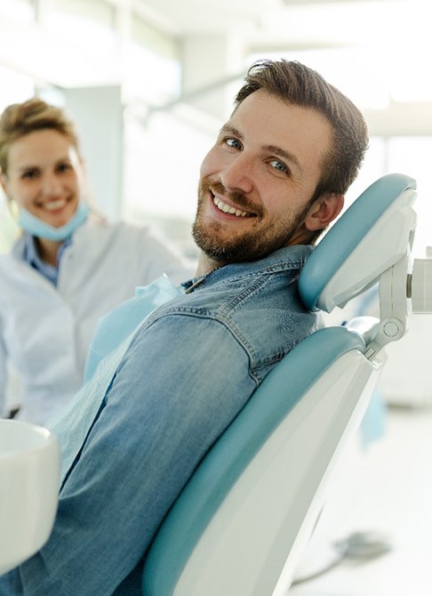 Man smiling while sitting in dental treatment chair