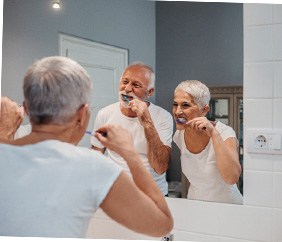 mature couple brushing teeth for cost of dental implants in Mankato       