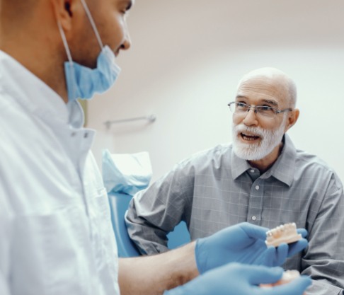 Man and dentist discussing the four step dental implant process