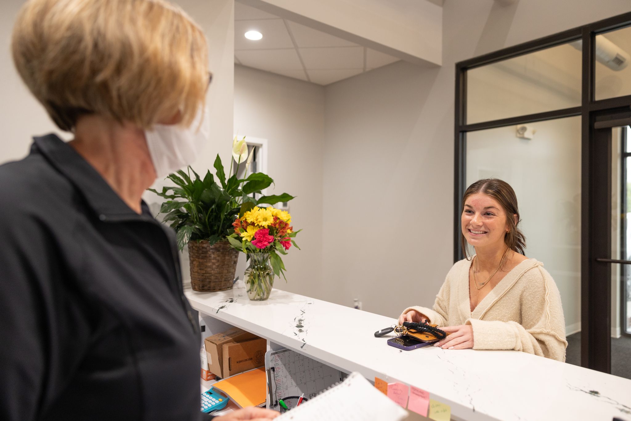 Dental patient talking to smiling dentistry team member