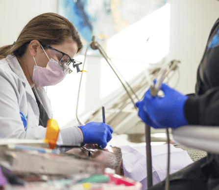 Dentist examining patient's smile after tooth colored filling treatment