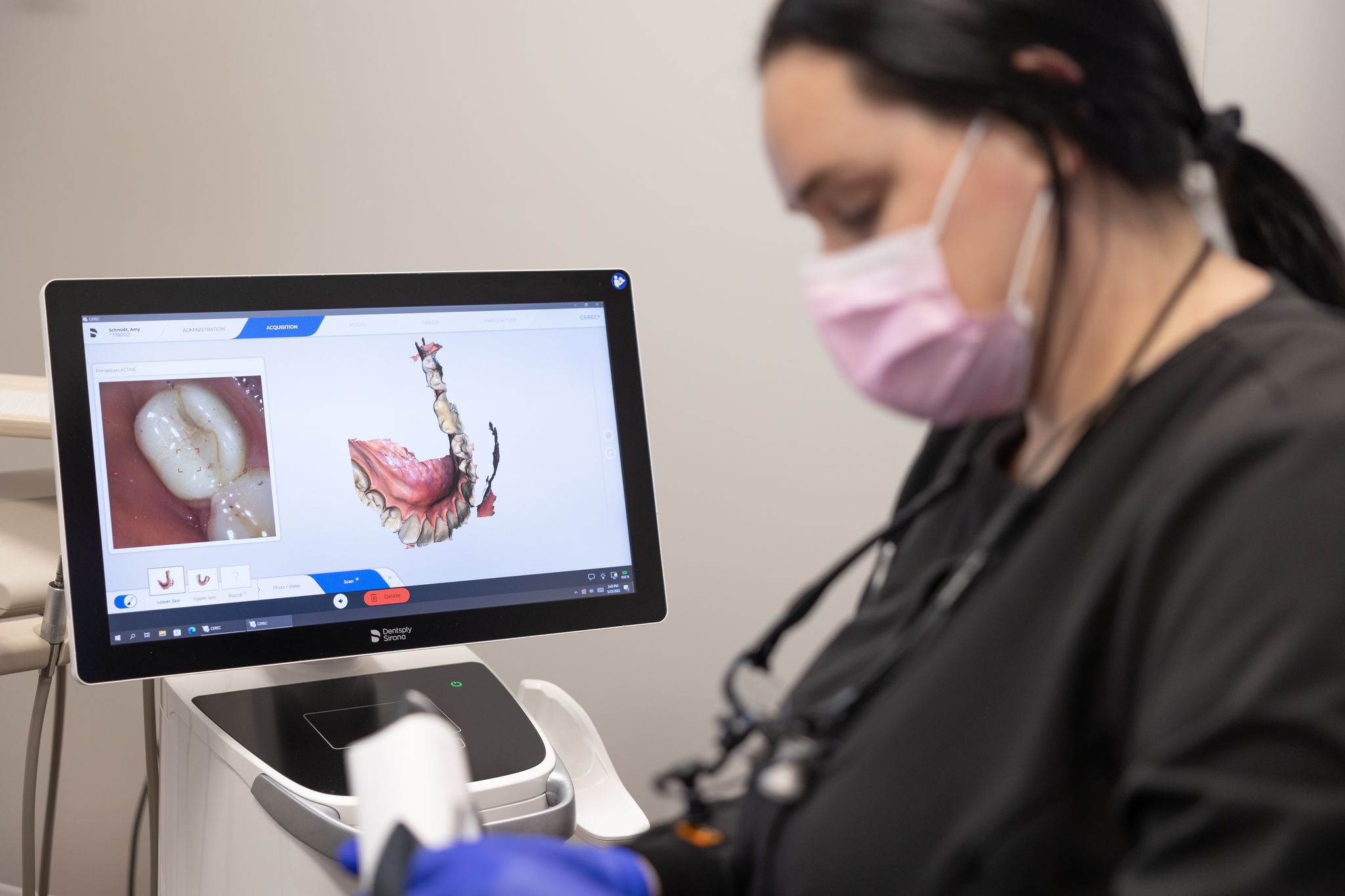 Dental team member using in office CEREC one visit dentistry milling unit connected to digital impression system