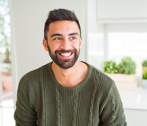 a smiling person sitting in a kitchen