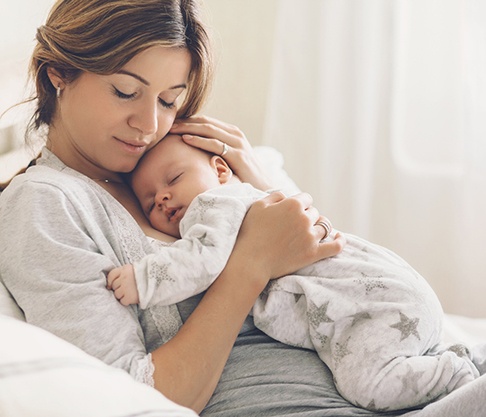 A mother with her baby asleep on her chest