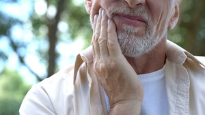 Close-up of bearded man with jaw pain